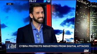 Guest expert discussing protection of industries from digital attacks on a television news set with a city skyline backdrop