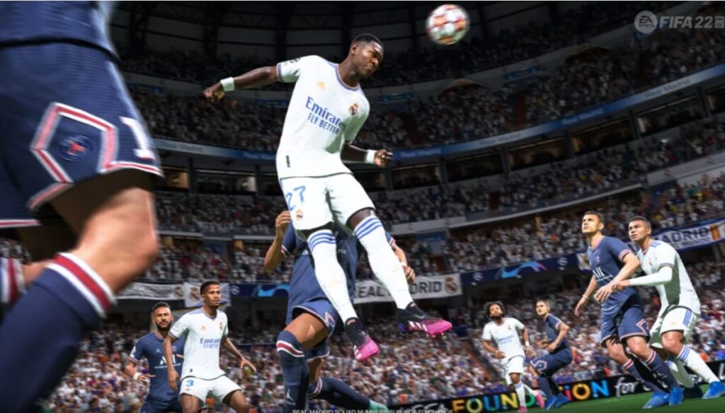 Real Madrid player leaping to head the ball amid Paris Saint-Germain defenders in an EA Sports FIFA 23 match
