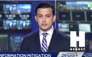 Television news anchor delivering a segment on misinformation mitigation, control room monitors in the background and a prominent Hearst logo on screen