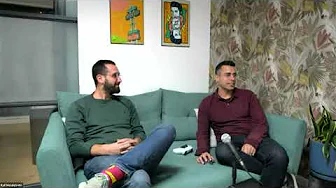 Two men seated on a green sofa with a microphone, recording a conversation for Cyabra virtual event