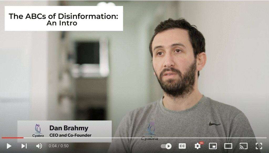 Video still featuring a man in a gray shirt speaking, with overlay text reading “The ABCs of Disinformation: An Intro” in the upper left corner