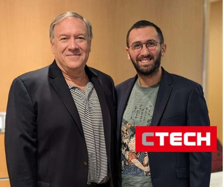 Two men wearing blazers smiling for a photo in an indoor setting, red CTech logo displayed in the corner