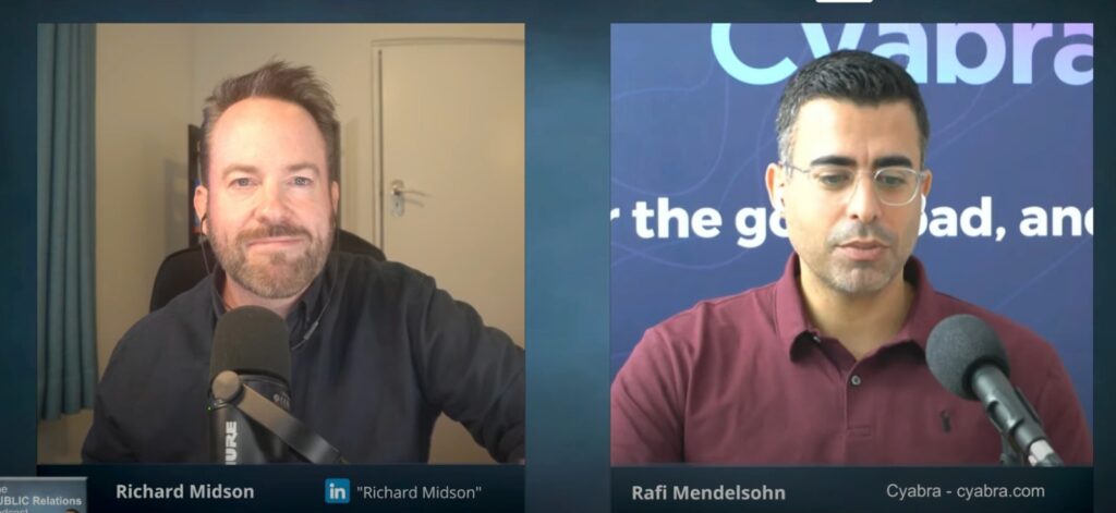 Split-screen video podcast interview showing two men speaking into microphones, one bearded in a dark shirt and the other wearing glasses and a maroon polo with a Cyabra-branded backdrop