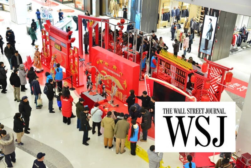 Crowd gathers around a red-themed DeepSeek technology exhibit inside a Chinese shopping mall decorated with festive New Year elements