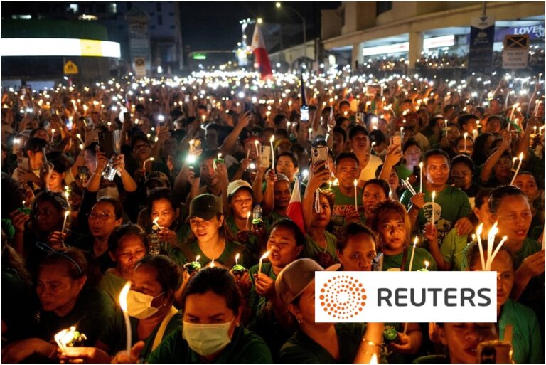 Large crowd of Filipinos in green shirts holding candles and phone flashlights during a nighttime political rally in Manila