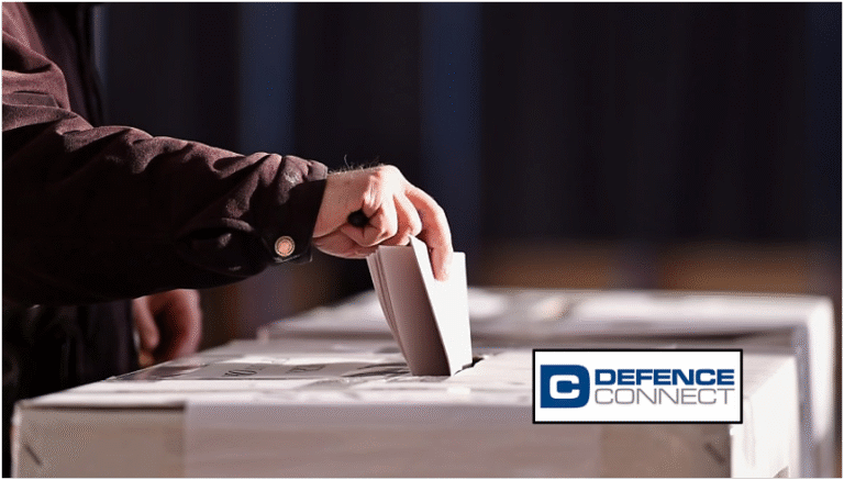 Person casting a vote by placing a ballot into a ballot box, symbolising recent elections and concerns over electoral interference