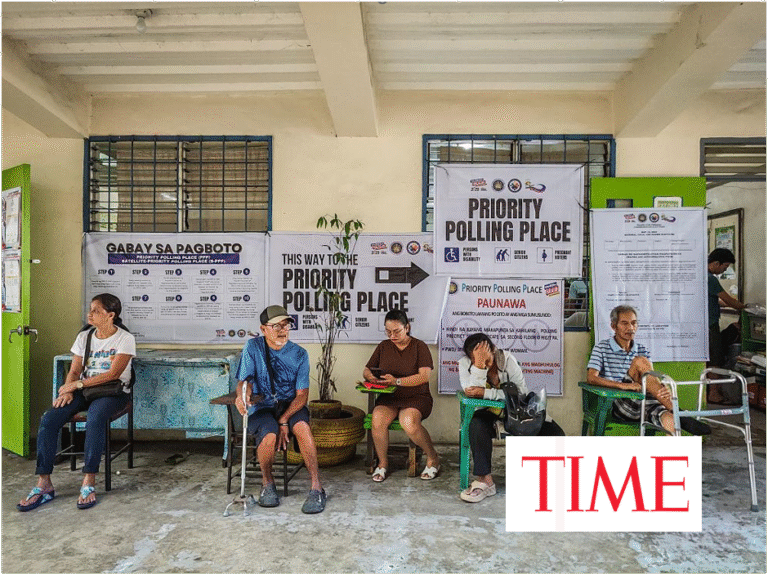 Voters, including elderly people and a man with crutches, sit waiting in a priority polling area in the Philippines, with posters directing to the Priority Polling Place on the wall behind them