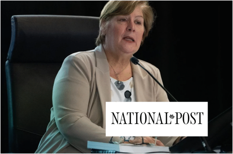 Woman in beige blazer speaking into a microphone at a hearing with National Post logo superimposed