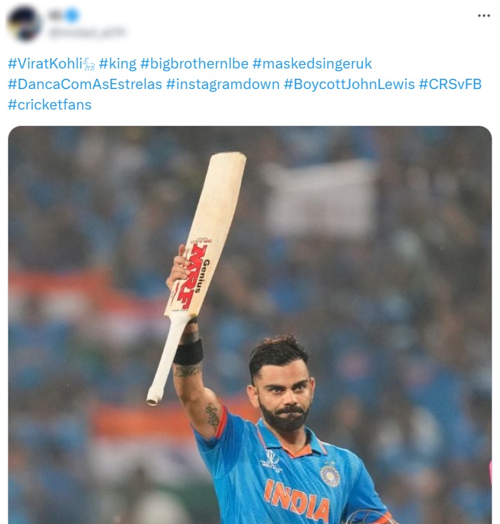 Social media post with multiple hashtags and a photo of a cricketer in a blue India jersey holding a bat aloft during a match